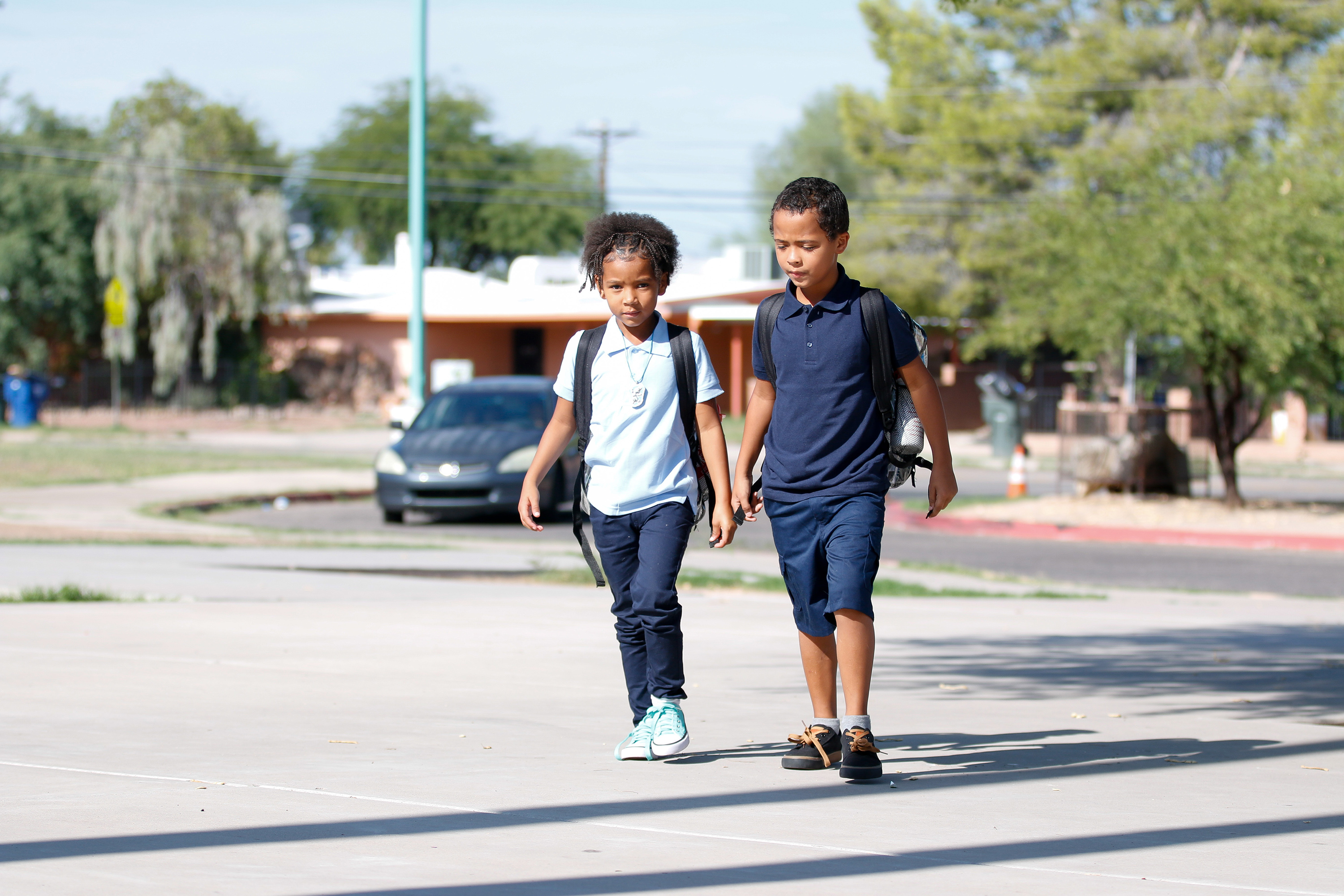 Two boys walk to school together on the second day