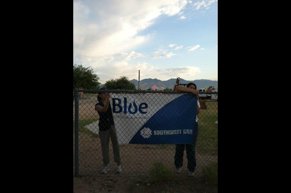 Women hand Southwest Blue banner on fence