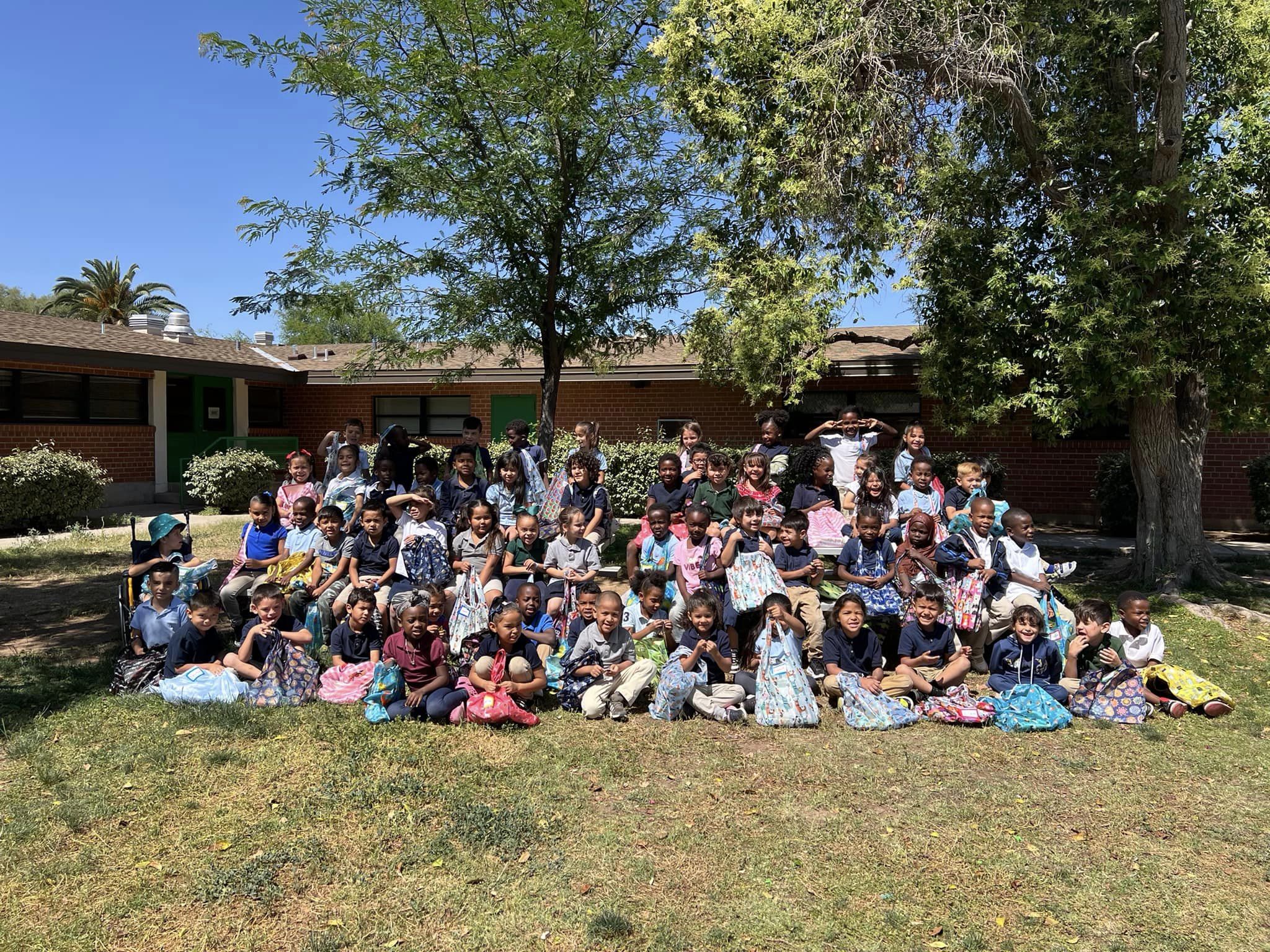 A group of students pose outside the school