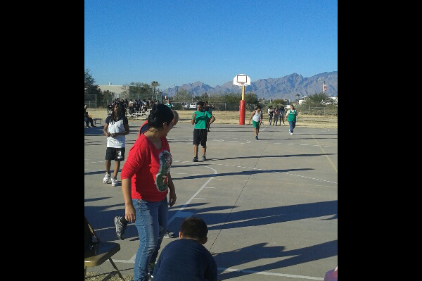 Staff and students play basketball on court