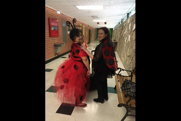 2 Teachers dressed up in ladybug costumes in school hallway