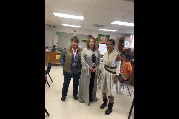 Teachers dressed in Halloween costumes standing in a classroom 