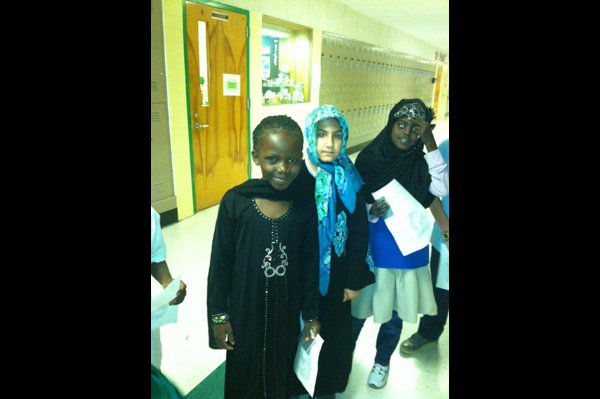 Students dressed in traditional heritage clothing lined up in hallway 
