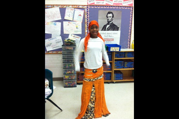 Student dressed in traditional heritage clothing standing in classroom
